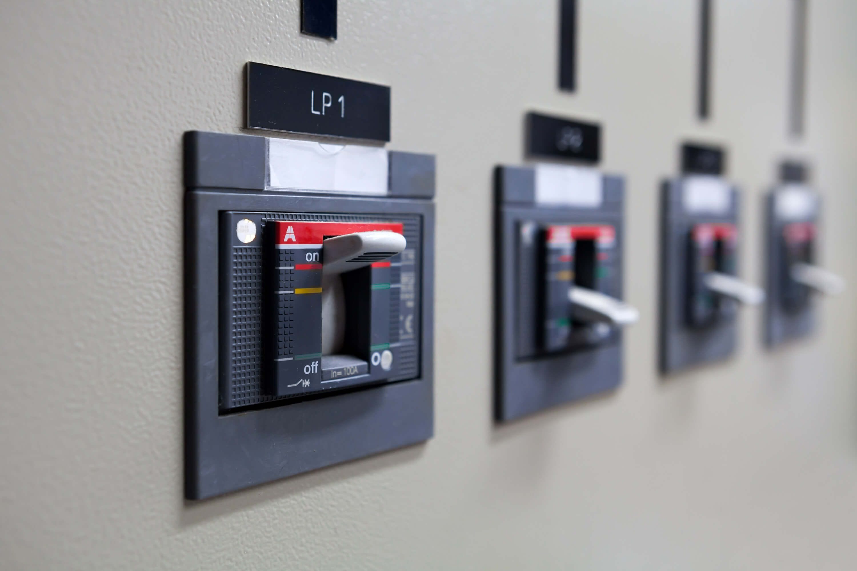 A row of moulded-case circuit breakers in a finished ECS distribution panel.